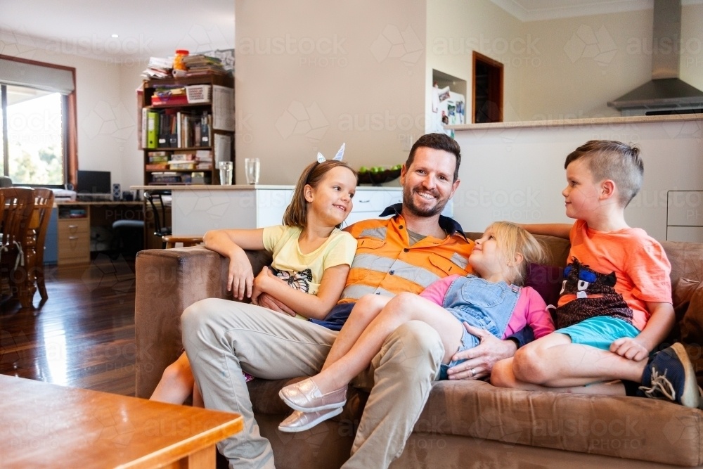 relaxed-tradie-hanging-out-with-his-kids-on-lounge-austockphoto-000101729